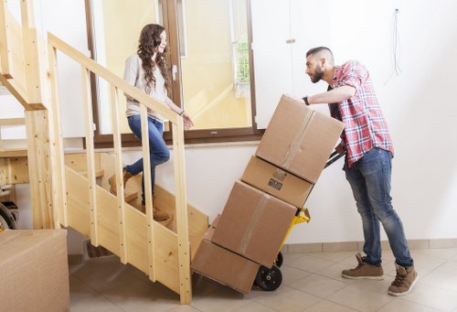 Loading dining furniture into a removals vehicle in Barnes
