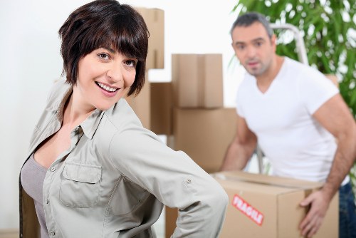 Trained movers using safe lifting techniques and moving equipment